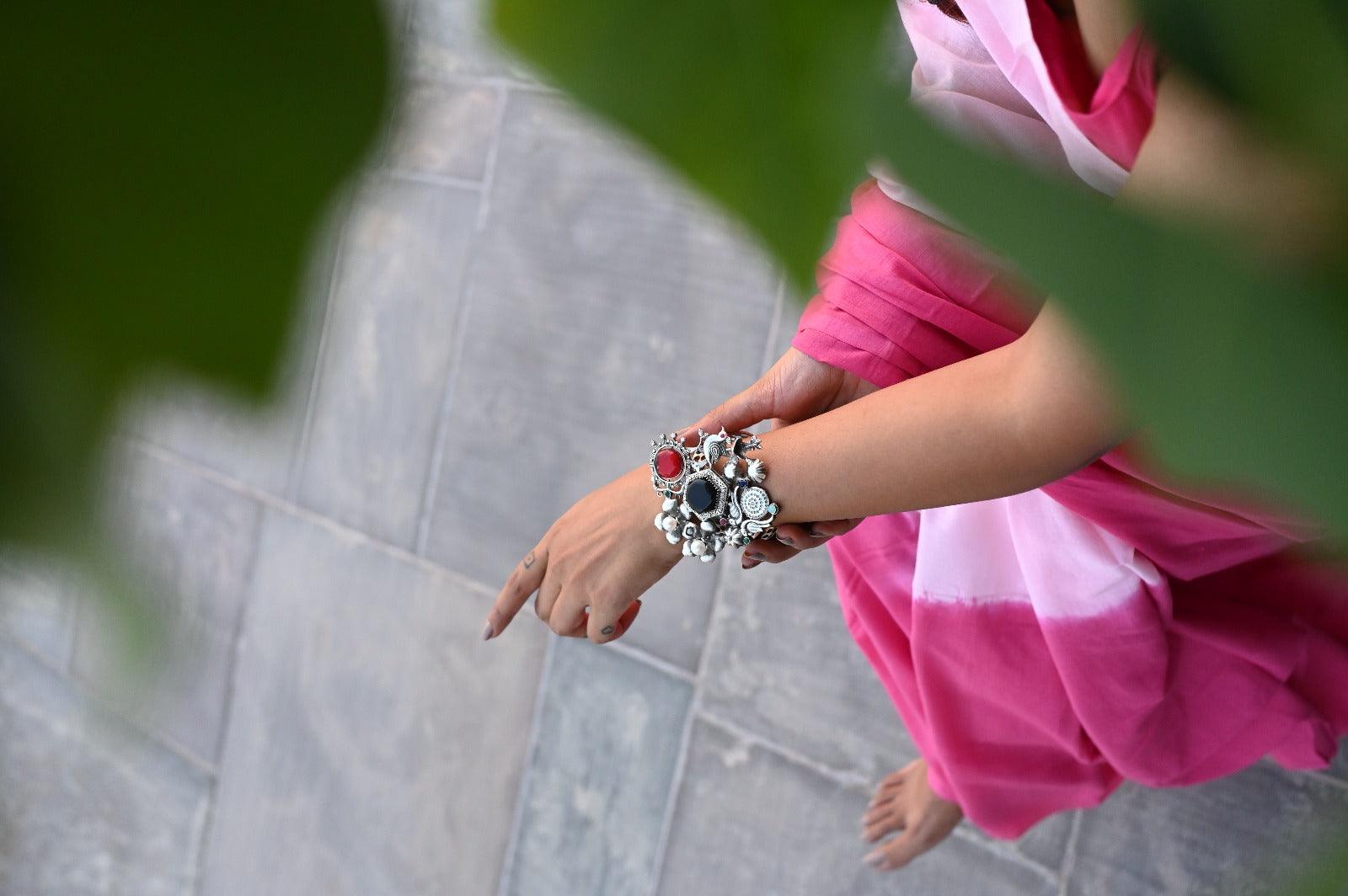 A woman wearing a delicate bracelet under the shimmering sunny day.